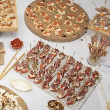 Vista cenital de la mesa de bienvenida con tablas de embutidos y canapés