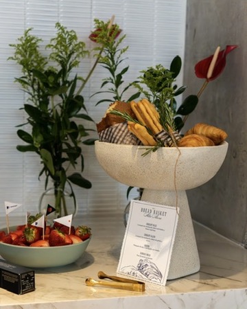 Cesta de panes artesanales con fresas y tarjeta de menú de Alta Mesa