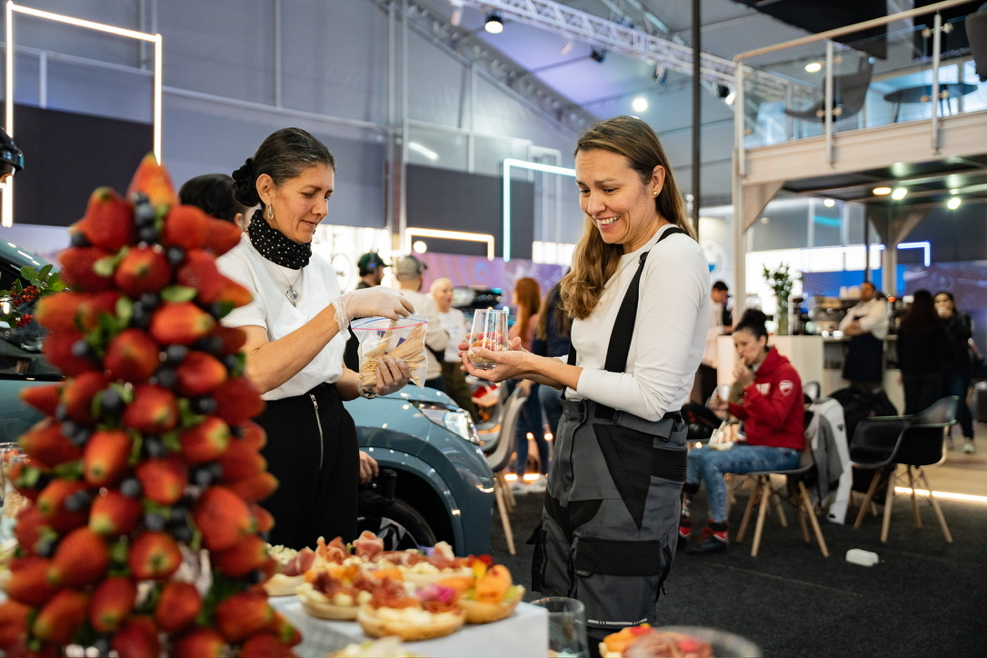 Estación gastronómica de Alta Mesa en un stand de marca durante una feria de autos