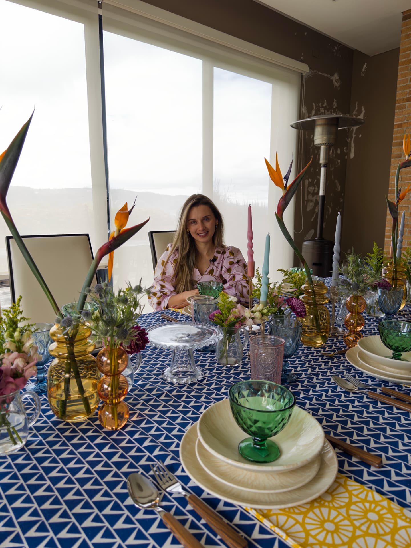 Mesa vestida con mantel azul geométrico, cristalería de colores y aves del paraíso